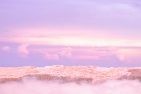Stone podium tabletop floor in outdoor on sky pink gold pastel soft cloud blurred background.Beauty cosmetic product placement pedestal present promotion stand display,summer paradise dreamy concept.の写真素材