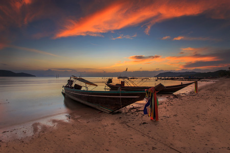 Traditional thai boats at sunset beachの写真素材