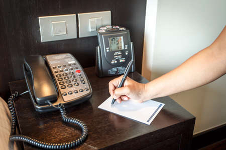 Hand holding pen with telephoneの写真素材