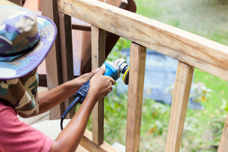 Hand holding angle grinder and work on timberの写真素材