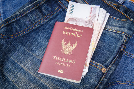 Thailand Passport and money in denim jeans pocketの写真素材
