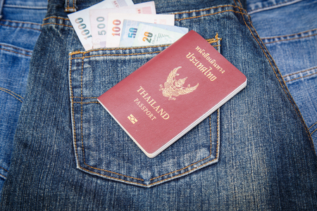 Thailand Passport and money in denim jeans pocketの写真素材
