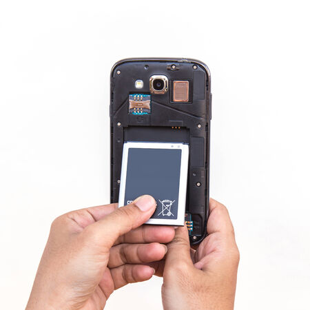 hand holding a battery and smartphone isolated on white background
