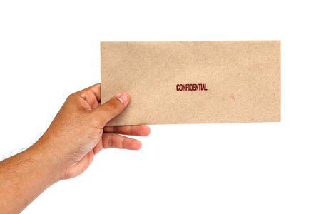 Hand holding Brown envelope with confidential stampの写真素材