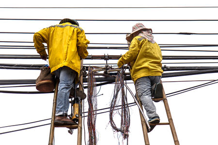 worker on bamboo ladder is repairing telephone lineの写真素材