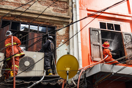 Fireman using water hose to prevent fireのeditorial素材