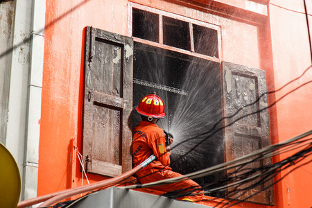 Fireman using water hose to prevent fireのeditorial素材