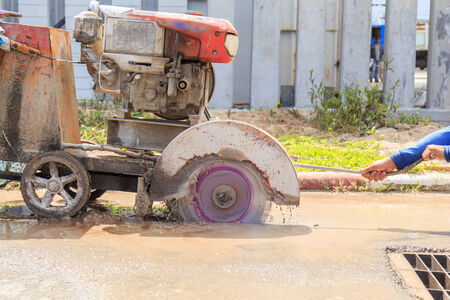 Road workers cutting asphalt roadの写真素材
