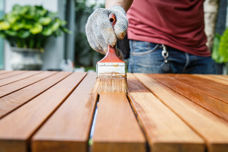 Brush in hand and painting on the wooden tableの写真素材
