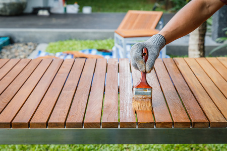 Brush in hand and painting on the wooden tableの写真素材