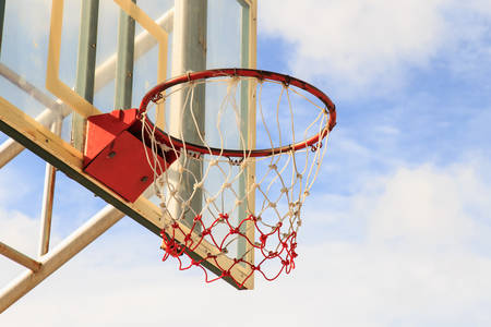 Basketball hoop with cage with blue sky backgroundの写真素材