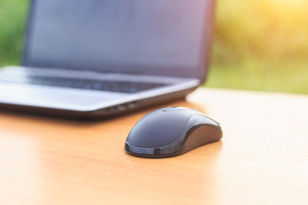Close up mouse and laptop on the table in the morning
