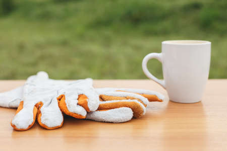 Close up coffee cup and safety glove on the table