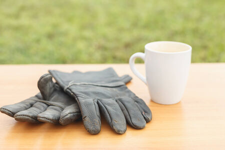 Close up coffee cup and safety glove on the table
