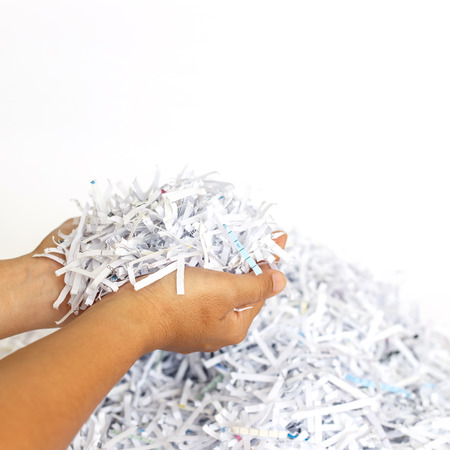 Hand holding Scrap Paper from paper cutterの写真素材