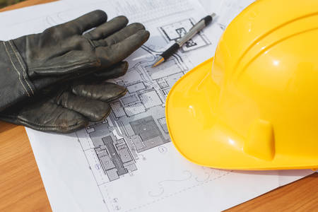 Close up Yellow safety helmet and floor plan drawings on the tableの写真素材