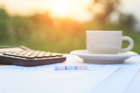 Balance written in letter beads and a coffee cup on tableの写真素材