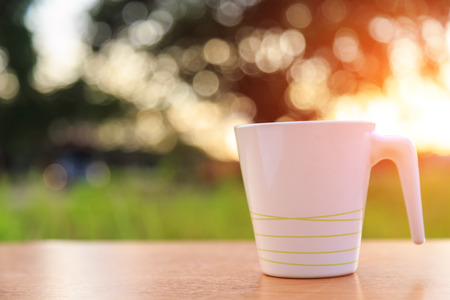 Coffee cup on the table in sunset timeの写真素材