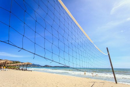 A beach volleyball net on the beach with a clear and sunny skyの写真素材