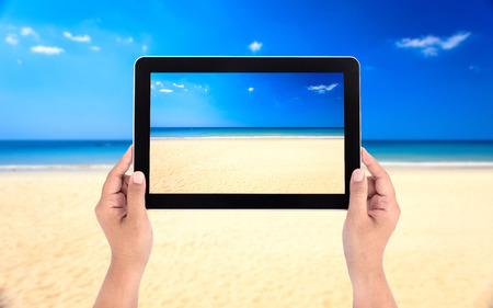 Hands holding tablet taking picturesの写真素材