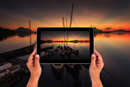 Hands holding tablet taking picturesの写真素材