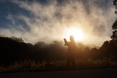 Silhouette of man taking photo at the mountain in Chiang Mai, Thailandの写真素材