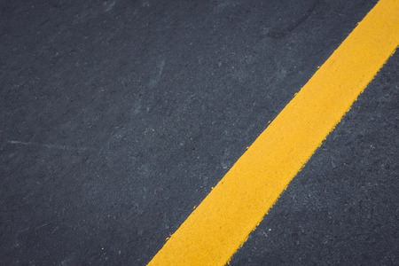 Asphalt road texture with yellow stripeの写真素材