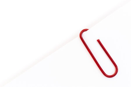 Red paper clip on white paperの写真素材