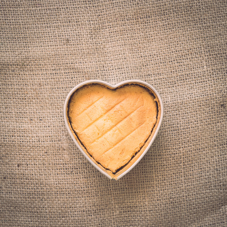 Heart butter cake on old crumpled burlap, Backgroundの写真素材