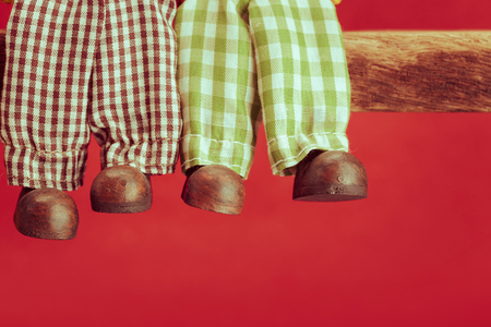 Legs of ceramic doll on red background, retro filter effectの写真素材