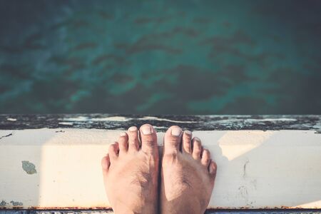 Bare Feet Standing on Cement Edge Near The Sea