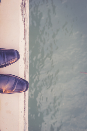 Feet with black shoe Standing on Cement Edge, suicide conceptの写真素材