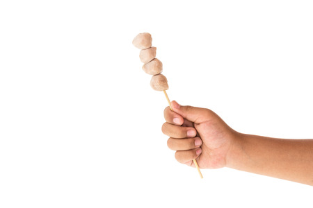 Close up hand holding meat ball isolated on white backgroundの写真素材