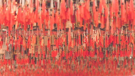 Close up small handmade bell with wood plate and red rope used for pray in Thailand, Vintage colorの写真素材