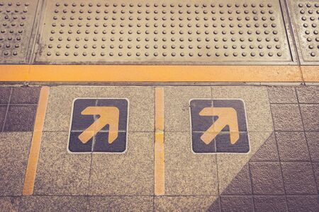 Close up Arrow sign on floor at the sky train station, bangkok, Thailandの写真素材