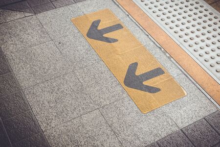 Close up Arrow sign on floor at the sky train station, bangkok, Thailandの写真素材