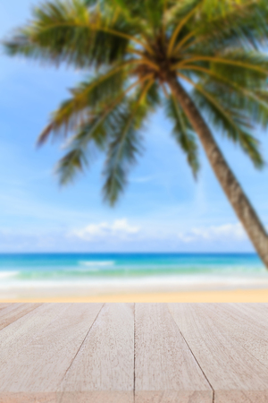 Close up top wooden table and blur of tropical beach backgroundの写真素材