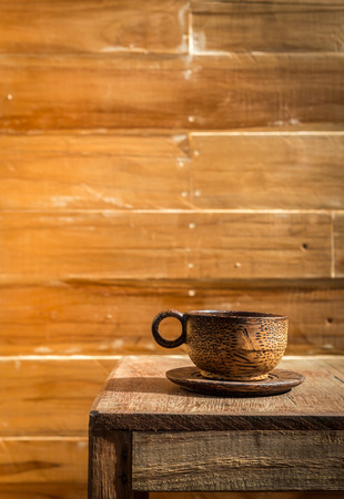 Close up palm wood coffee cup on wooden table and wooden wallの写真素材