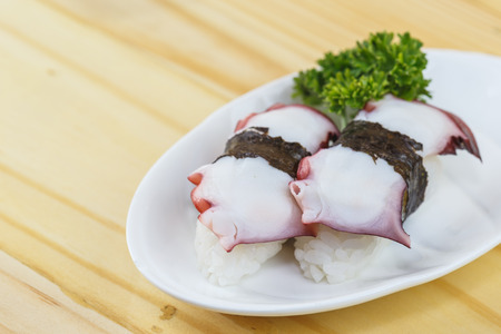 Traditional japanese food, Ika (Squid) maki on wooden tableの写真素材