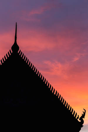 Silhouette Thai style temple roof and sunset backgroundの写真素材