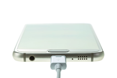 Macro Smartphone connect with charger isolated on white backgroundの写真素材