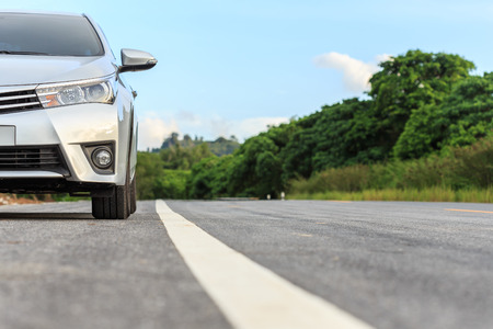 New silver car parking on the asphalt road in Thailandの写真素材