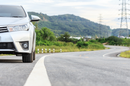 New silver car parking on the asphalt road in Thailandの写真素材
