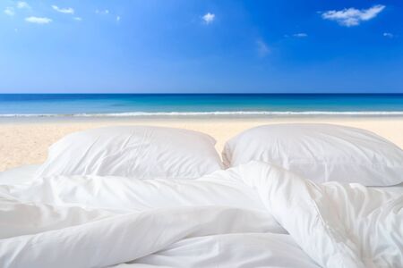 Close up white bedding sheets and pillow on view of sky backgroundの写真素材