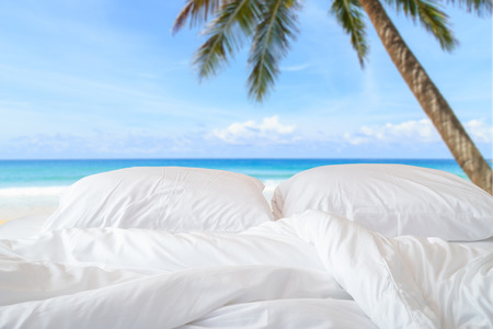 Close up white bedding sheets and pillow on view of sky backgroundの写真素材