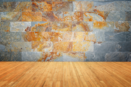 Empty top of wooden floor and natural stone wall backgroundの写真素材