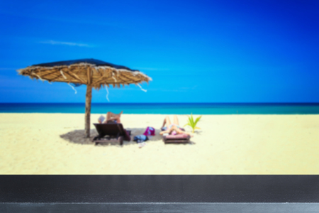 Empty top of natural stone table and view of tropical beach backgroundの写真素材