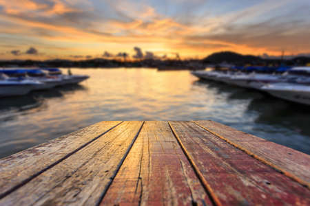 Close up top of old wooden table with blur sunset  backgroundの写真素材