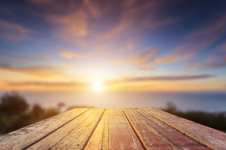 Close up top of old wooden table with blur sunset  backgroundの写真素材