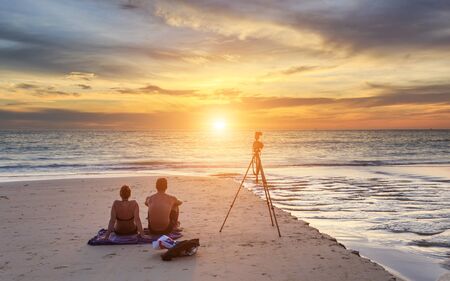 Couple sitting on the sunset beach, in Phuket Thailandの写真素材